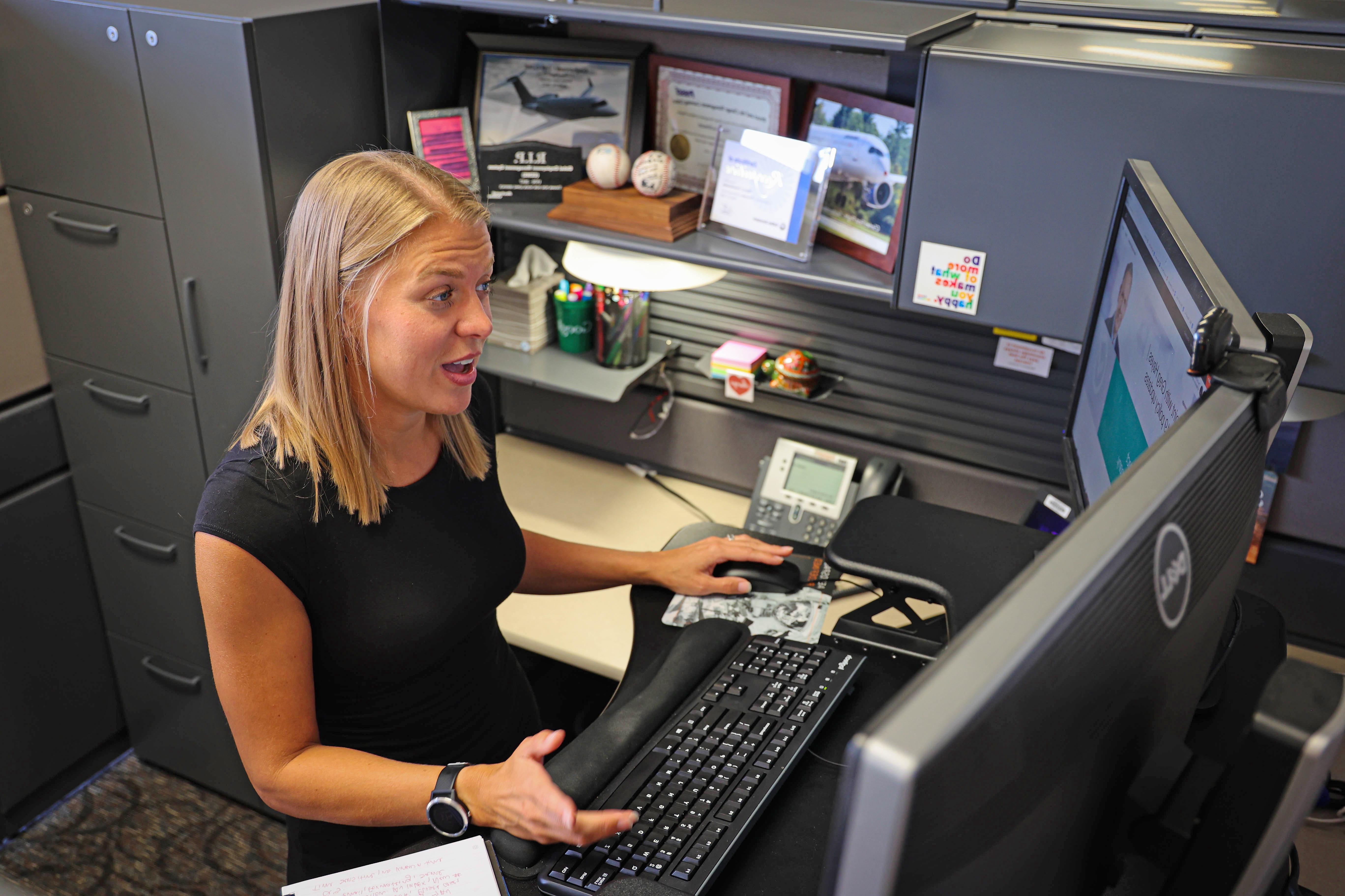 Piper, talking and sitting at her desk