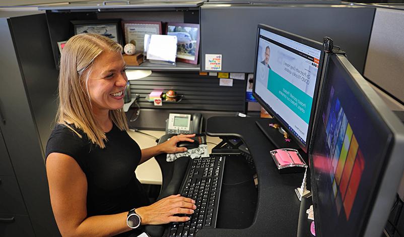 Piper smiling and working on her computer at Collins Aerospace